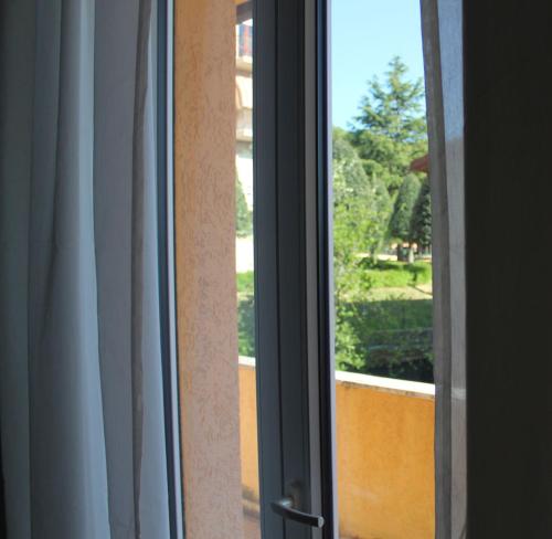 a sliding glass door with a view of a yard at Hotel La Ruota Dei Pavoni in Osimo