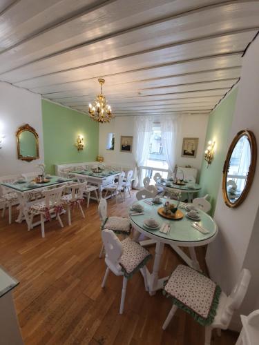 a dining room with tables and chairs and a chandelier at Pension Seibel in Munich