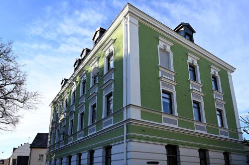 um edifício verde e branco com um céu ao fundo em Gemütliches Appartement mit Netflix, Nespresso und Boxspringbett em Augsburg