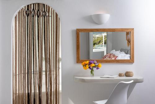 a bathroom with a mirror and a sink at Adamant Suites in Fira