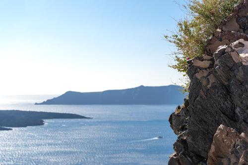 a view of the ocean from the side of a cliff at Adamant Suites in Fira