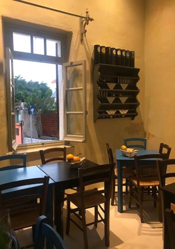 a dining room with tables and chairs and a window at Casa Mespilea in Paphos City