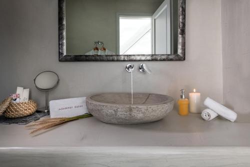 a bathroom with a stone sink and a mirror at Adamant Suites in Fira