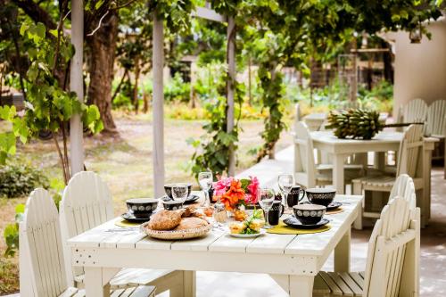 uma mesa branca com comida e flores em Addo African Home em Addo