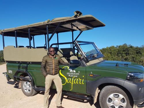 a man standing in front of a green jeep at Addo African Home in Addo