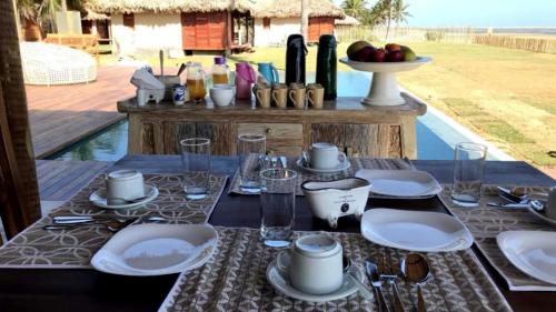 een tafel met borden en bestek erop bij Vila Ybytu Eco Resort in Itarema