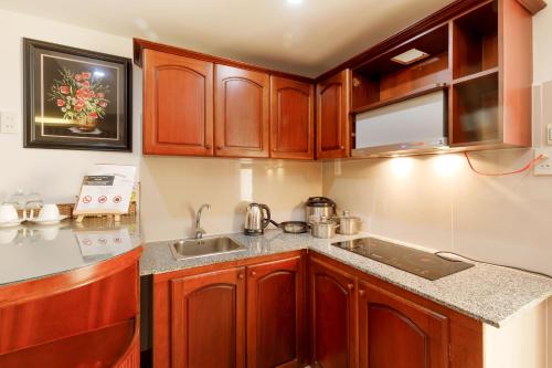 a kitchen with wooden cabinets and a sink at Paris Luxury Hotel & Apartment Nha Trang in Nha Trang