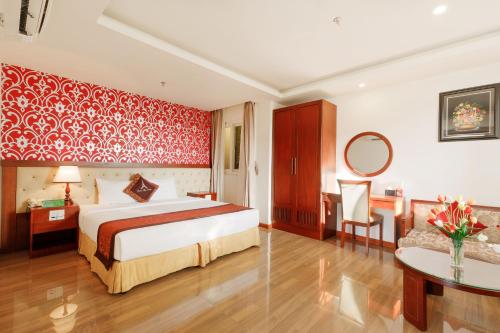 a bedroom with a bed and a red wall at Paris Luxury Hotel & Apartment Nha Trang in Nha Trang