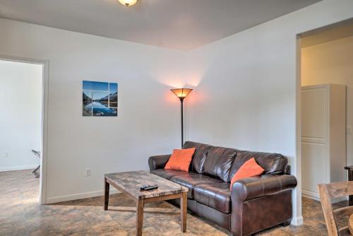a living room with a leather couch and a table at Homer Hideaway on Fritz Creekside - Pets Welcome in Homer