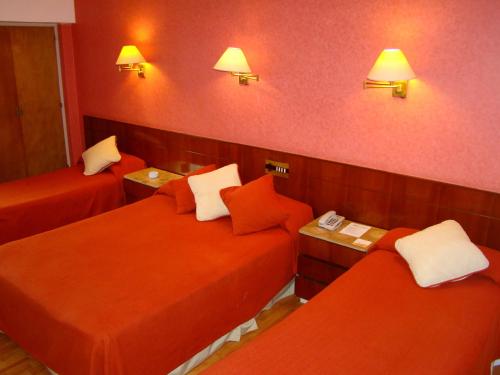 a hotel room with two beds and red walls at Gran Hotel Continental in Mar del Plata