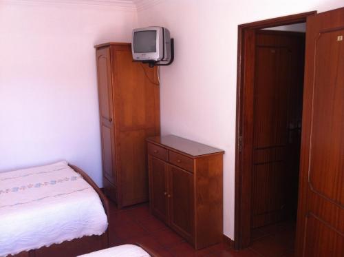 a bedroom with a bed and a tv on a wall at D. Antonia in Peniche
