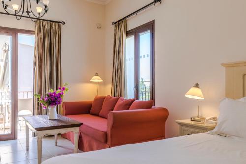 a hotel room with a couch and a bed at Aliathon Ionian in Paphos City