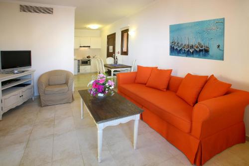 a living room with an orange couch and a table at Aliathon Ionian in Paphos City