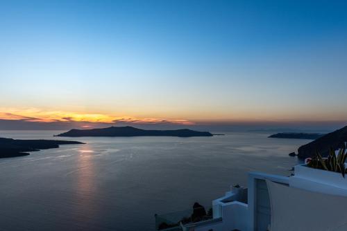 a view of the ocean at sunset from a building at Adamant Suites in Fira
