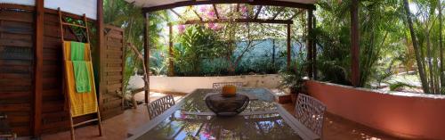 a patio with a glass table and a garden at Villa Rosa Karibella in Saint-François