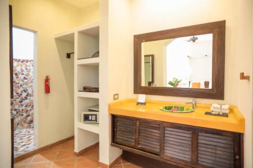 a bathroom with a sink and a mirror at Manala Hotel in Santa Teresa Beach