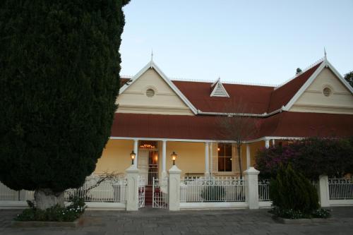 a white house with a red roof at Karoopark Guest House in Graaff-Reinet