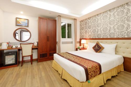 a bedroom with a bed and a desk and a mirror at Paris Luxury Hotel & Apartment Nha Trang in Nha Trang