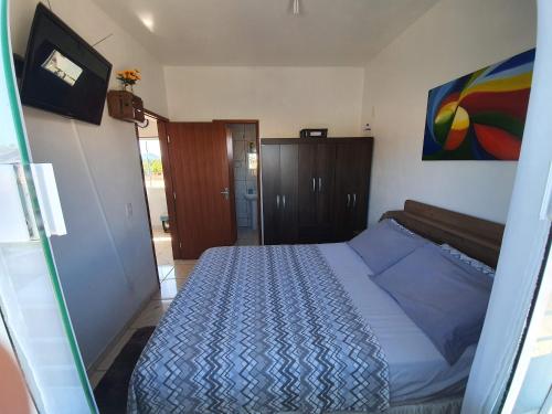 1 dormitorio con 1 cama y una pintura en la pared en Apartamento próximo ao Aeroporto de Florianópolis., en Florianópolis