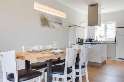 a kitchen and dining room with a wooden table and chairs at Fehmarn in List