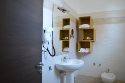 y baño con lavabo y ducha. en Palazzo Marignano Hotel, en Melegnano