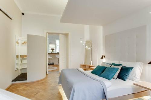 1 dormitorio blanco con 1 cama grande con almohadas azules en BRIGHT Prague Na Poříčí en Praga