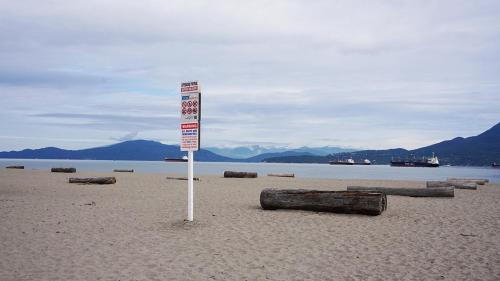 a sign in the sand on a beach at HI Vancouver Jericho Beach - Hostel in Vancouver