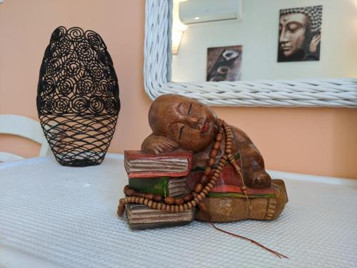 a statue of a monk sitting on a pile of books at Villa Rosa Karibella in Saint-François