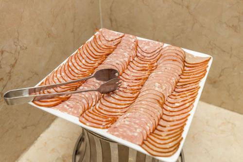 a plate of food with meat and a spoon at Paris Luxury Hotel & Apartment Nha Trang in Nha Trang
