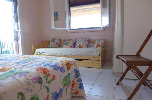 Habitación pequeña con cama y ventana en Rose Phœnix rez-de-jardin piscine et vue mer en Les Anses-dʼArlets