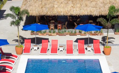 a resort with a pool and chairs and umbrellas at Decameron Isla Coral Guayabitos, Ramada All-Inclusive Resort in Rincon de Guayabitos