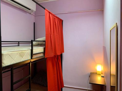 モスクワにあるTravel Inn Novoslobodskayaのベッドルーム1室(赤いカーテン付きの二段ベッド1組付)