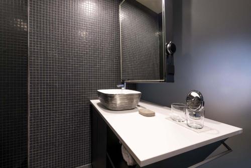 a bathroom with a sink and a mirror at 9Hotel Mercy in Lisbon