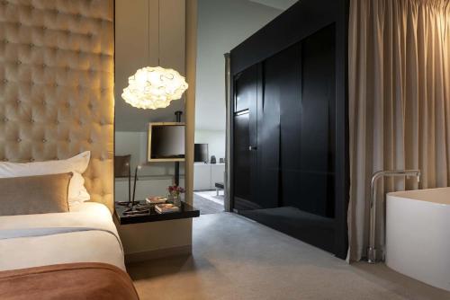 a bedroom with a bed and a large black door at 9Hotel Mercy in Lisbon