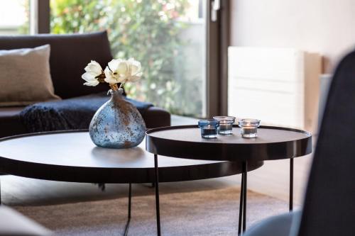 a living room with two tables and a vase with flowers at Shell Luxury Residences with Pool and Whirlpool in Zadar