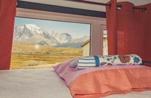 a bedroom with a bed with a view of a mountain at Goiien House in Torres del Paine