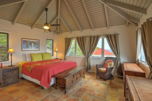 a bedroom with a bed and a chair and windows at St Thomas Cliffside Villa with Pool and Hot Tub! in Lovenlund
