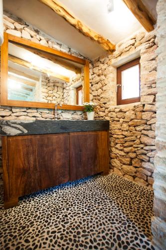 a bathroom with a sink and a stone wall at Casa Casita in Cala Saona