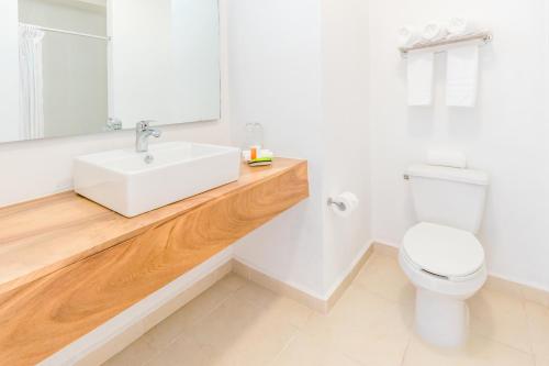 a bathroom with a white sink and a toilet at Decameron La Marina in Rincon de Guayabitos