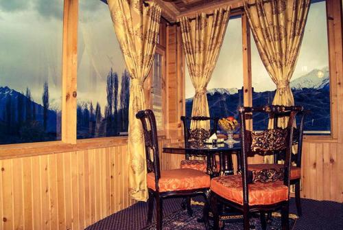 a room with two chairs and a table in front of a window at Fairy Land Hotel in Hunza Valley