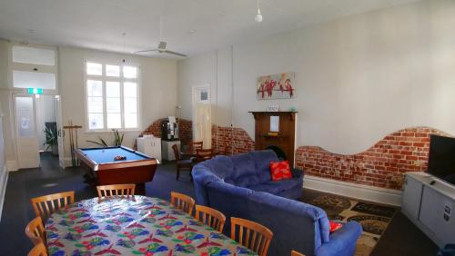 a living room with a blue couch and a table at Geraldton Backpackers in Geraldton