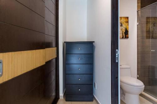 La salle de bains est pourvue d'une commode bleue et de toilettes. dans l'établissement Increible Loft en PH Zona Polanco B, à Mexico
