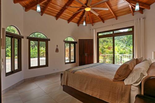 um quarto com uma cama grande e janelas em Stunning Casa de la Roca House with Infinity Pool! em Ojochal
