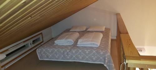 a bedroom with a bed with two pillows on it at JaakopinPaja A&B in Levi