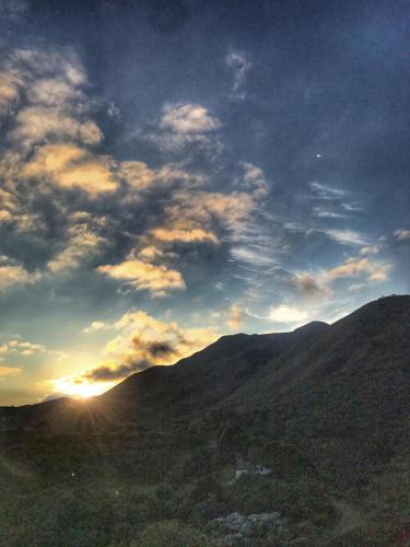 a sky with the sun setting over a mountain at Hotel Recanto do Ouro in Ouro Preto