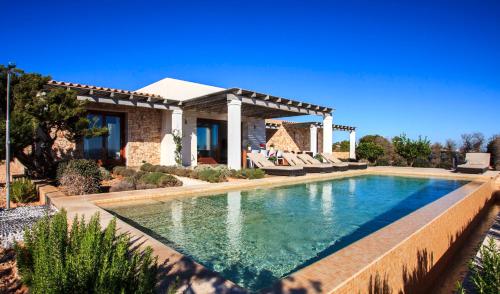 a swimming pool in front of a house at Casa Santolina in Cala Saona