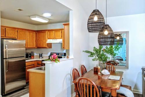 a kitchen with a table and a stainless steel refrigerator at RARE Downtown Matthews walk 2 shops restauraunts hike CLT 2 Bedroom not 3br in Charlotte
