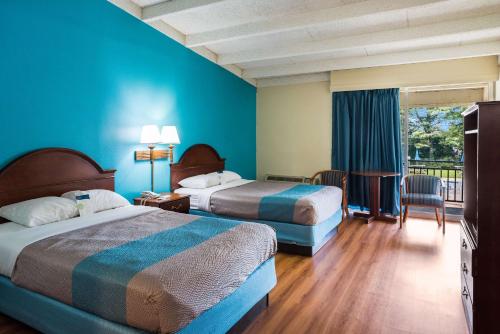 2 łóżka w pokoju hotelowym z niebieskimi ścianami w obiekcie Motel 6-Philadelphia, PA - Northeast w Filadelfii