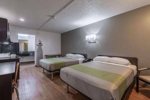 a hotel room with two beds and a kitchen at Studio 6-Bryan, TX - University Area in Bryan