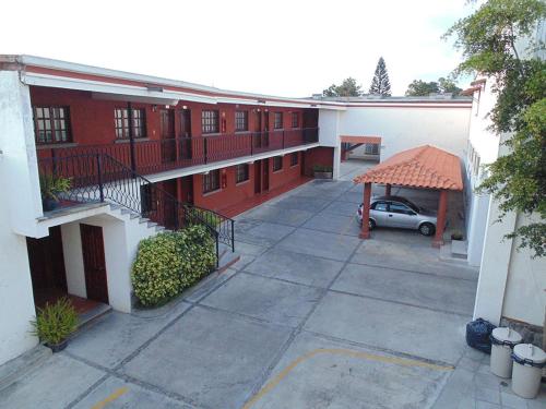 an apartment building with a car parked in the courtyard at Hotel Hacienda in Ciudad Guzmán